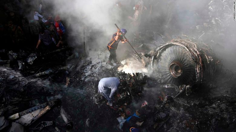 Các tình nguyện viên Pakistan đang đào bới tàn dư của chuyến bay PK 8303 vào ngày 22/5. Ảnh: CNN