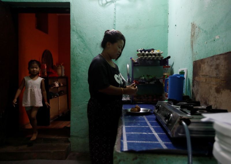 Bà nội trợ Limbu đang nấu ăn trong bếp cùng con gái mình tại phòng trọ ở thủ đô Baniyatar. Ảnh: REUTERS