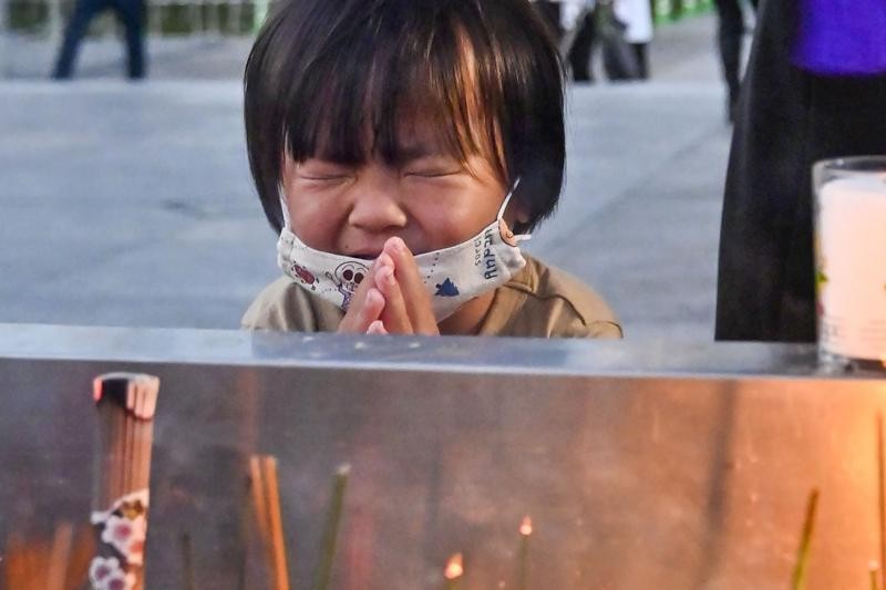 Một em nhỏ cầu nguyện trước tượng đài dành riêng cho các nạn nhân của vụ ném bom nguyên tử tại Công viên Tưởng niệm Hòa bình Hiroshima. Ảnh: AP