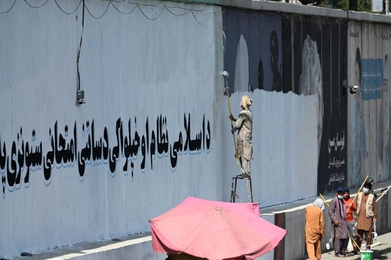 Trong vòng vài tuần sau khi chiếm được Kabul, Taliban đã bắt đầu xóa bỏ nhiều bức tranh tường bằng các khẩu hiệu tuyên truyền. Ảnh: AFP