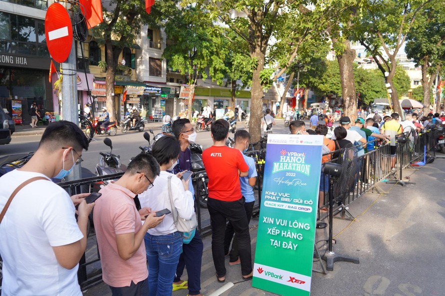 Các VĐV xếp hàng vào khu vực nhận BIB. Theo thống kê của BTC, VPHM 2022 thu hút hơn 10.000 VĐV đăng ký tham gia và hiện đang là giải chạy có số lượng VĐV tham dự cự ly 42 km lớn nhất Việt Nam 