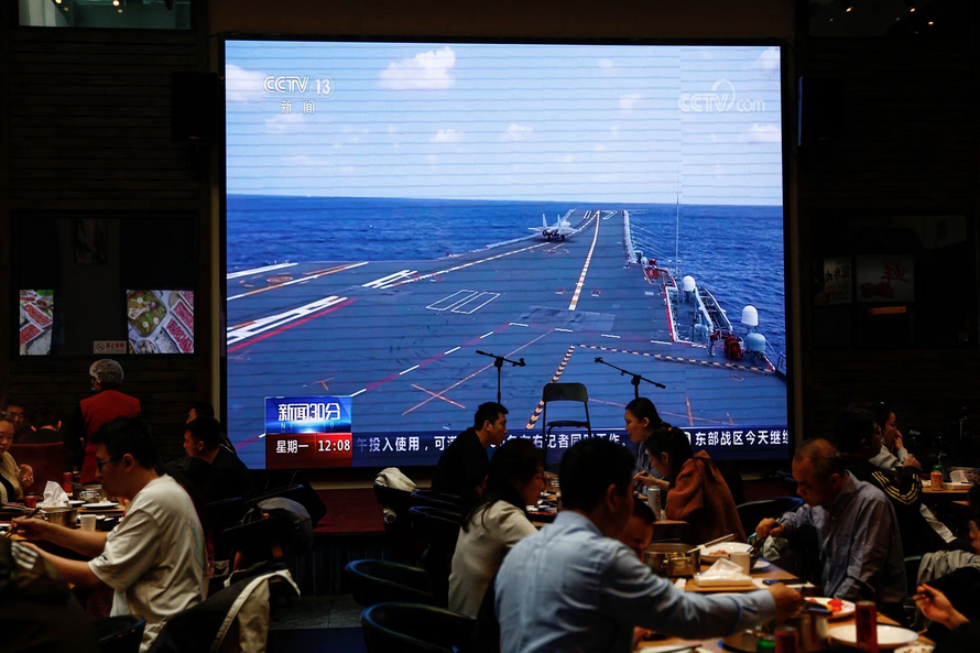 Một nhà hàng tại Bắc Kinh phát hình ảnh máy bay cất cánh trên tàu sân bay Sơn Đông. Ảnh: Reuters