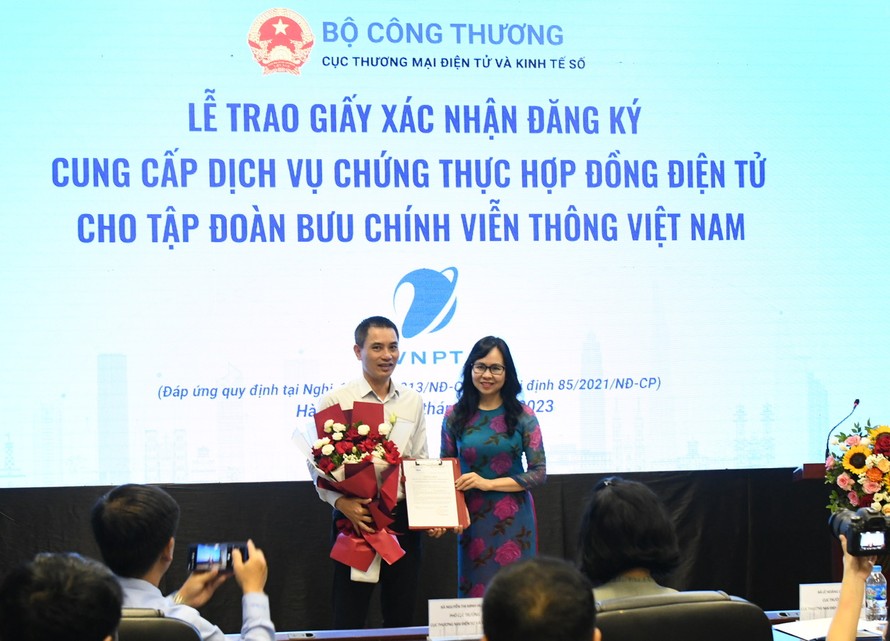 Bà Lê Hoàng Oanh – Cục trưởng Cục thương mại điện tử và Kinh tế số trao giấy xác nhận đăng ký cung cấp dịch vụ chứng thực hợp đồng điện tử cho đại diện Tập đoàn VNPT.