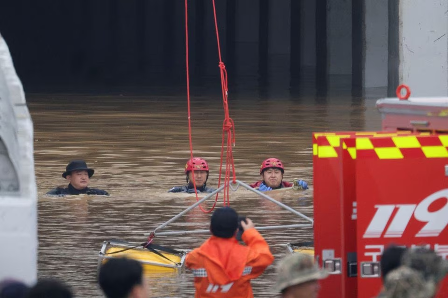 Nhân viên cứu hộ đã phải lặn xuống nước lũ để tìm kiếm những người mất tích. Ảnh: Reuters