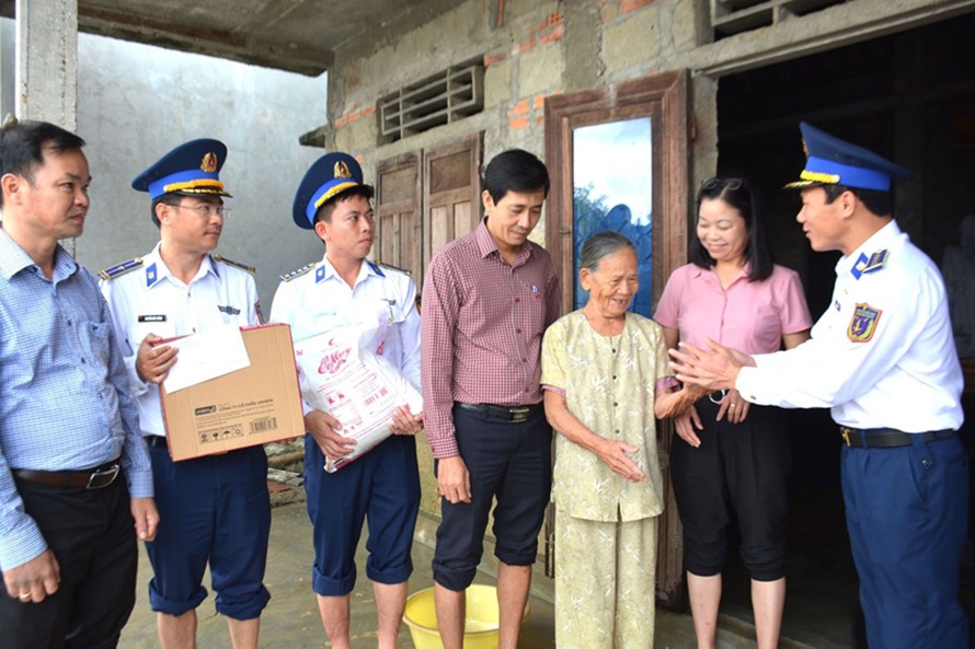 Đại tá Trần Hồng Quế - Phó Chính ủy Vùng Cảnh sát biển 2 cùng đoàn công tác đến thăm hỏi, động viên và trao quà tặng bà Văn Thị Em (80 tuổi, trú tại thôn Phú Lộc, xã Phong Chương).