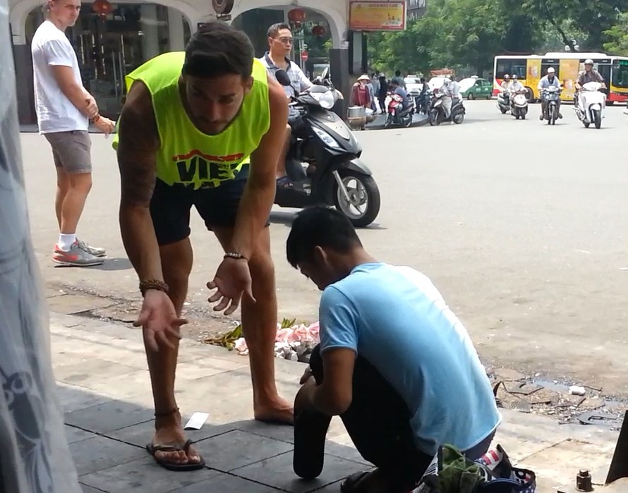 Một du khách bị ép đánh giầy trên đường phố Hà Nội (Ảnh Internet)