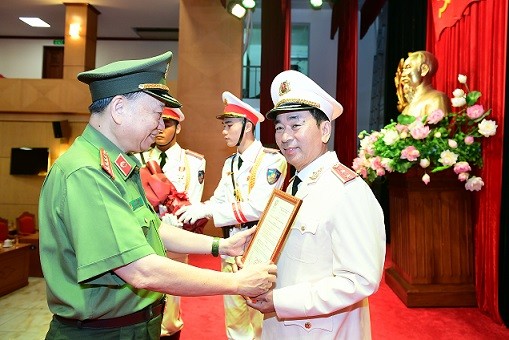 Bộ trưởng Tô Lâm trao Quyết định của Chủ tịch nước thăng cấp bậc hàm từ Thiếu tướng lên Trung tướng đối với đồng chí Trần Quốc Tỏ.