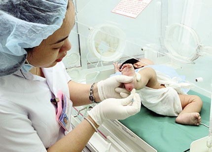 Lấy máu gót chân để thực hiện sàng lọc sơ sinh tại bệnh viện.