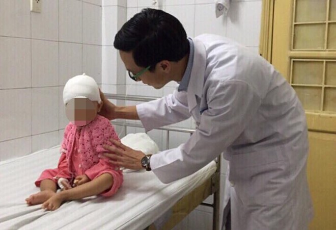 ThS.BS Nguyễn Mạnh Hùng, khoa Phẫu thuật Thần kinh thăm khám cho bệnh nhi sau phẫu thuật. Ảnh: HY.