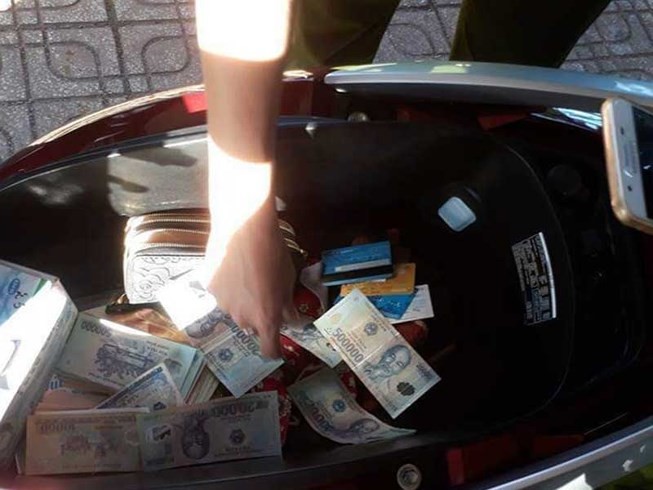 Nhiều tờ tiền bị cắt, ghép được phát hiện trong cốp xe của Nguyễn Thị Khẩn. Ảnh: CAO DIÊN