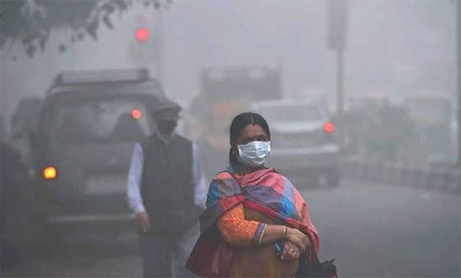 Một phụ nữ Ấn Độ mang khẩu trang để đối phó với bầu không khí ô nhiễm mịt mù - (Ảnh: AFP).