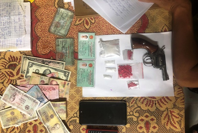 Tang vật súng ru-lô, ma túy, tiền, đô-la thu giữ từ đối tượng ma túy.