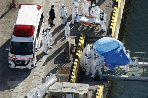 Nhân viên y tế chuyển du khách bị nhiễm virus corona chủng mới trên du thuyền Diamond Princess lên xe cứu thương tại cầu tàu ở Yokohama ngày 5/2/2020. (Ảnh: Kyodo/TTXVN)