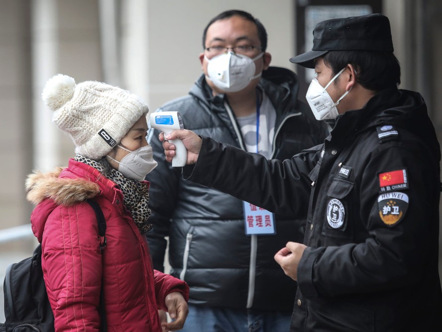 Nhân viên an ninh kiểm tra nhiệt độ của hành khách tại bến sông Dương Tử ở Vũ Hán, tỉnh Hồ Bắc, Trung Quốc. Ảnh: Getty Images