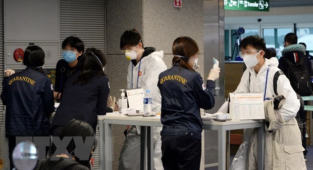 Nhân viên tiến hành công tác kiểm dịch đối với hành khách tại sân bay Incheon, phía tây thủ đô Seoul, Hàn Quốc, ngày 23/3/2020. (Nguồn: Yonhap/TTXVN)