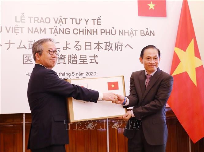 Thứ trưởng Bộ Ngoại giao Lê Hoài Trung trao cho Đại sứ Nhật Bản tại Việt Nam Yamada Takio tượng trưng vật tư y tế của Chính phủ Việt Nam hỗ trợ Chính phủ và nhân dân Nhật Bản phòng, chống dịch COVID-19. Ảnh: Lâm Khánh/TTXVN