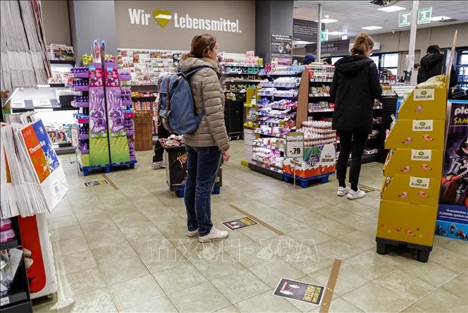 Người dân thực hiện giãn cách xã hội nhằm chống dịch COVID-19 tại một siêu thị ở Berlin, Đức ngày 23/3/2020. Ảnh: THX/TTXVN