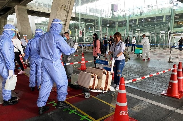 Các nhân viên y tế tiến hành kiểm tra thân nhiệt những người Thái hồi hương từ Abu Dhabi và Ai Cập, hôm 8/5. (Ảnh: Bangkok Post).