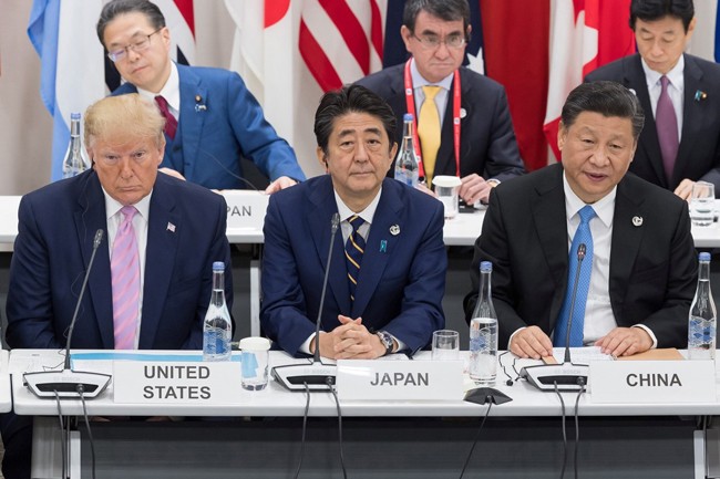 Thủ tướng Nhật Bản Minister Shinzo Abe ngồi giữa Tổng thống Mỹ Donald Trump và Chủ tịch Trung Quốc Tập Cận Bình trong một sự kiện. Ảnh: AFP