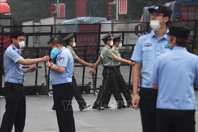 Cảnh sát gác tại lối vào chợ Tân Phát Địa ở Bắc Kinh, Trung Quốc, ngày 13/6, sau khi chợ phải đóng cửa do phát hiện ca nhiễm COVID-19 mới. Ảnh: AFP/TTXVN