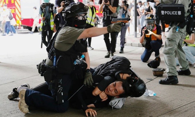Cảnh sát ghì người biểu tình xuống đất tại Hong Kong. Ảnh: Reuters.