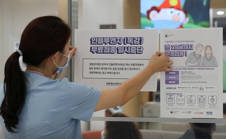 Nhân viên y tế dán thông báo tạm ngưng chương trình tiêm phòng cúm tại một bệnh viện ở Sejong. Ảnh: Yonhap