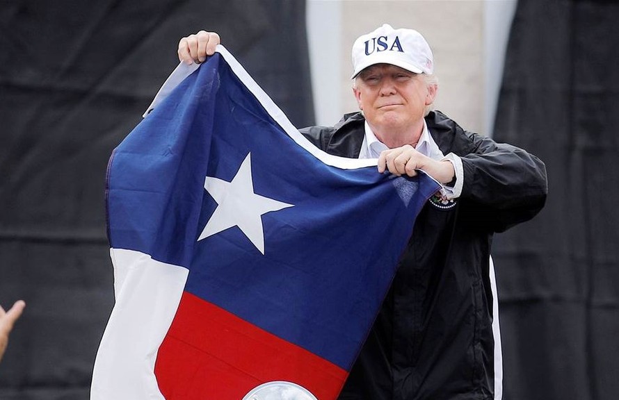 Tổng thống Trump vẫy lá cờ của tiểu bang Texas trong một cuộc vận động. Ảnh: AP.