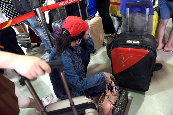 Mệt mỏi chờ đợi trước cửa khu vực an ninh soi chiếu tại nhà ga quốc nội sân bay Tân Sơn Nhất trưa 18/4 - Ảnh: Duyên Phan 