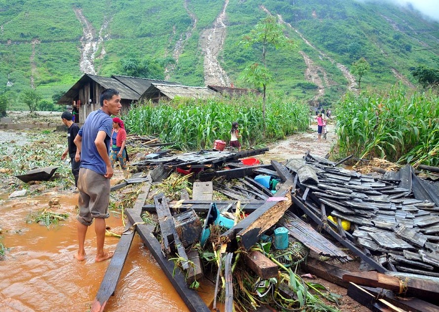 Người dân thôn Tùng Lùn ngậm ngùi nhìn ngôi nhà chỉ còn lại đống gỗ ngổn ngang. (Ảnh: vietnamnet.vn)