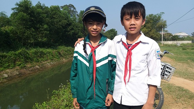 Em Nguyễn Văn Chương (áo khoác xanh) và em Nguyễn Phi Anh đã cứu sống 2 em nhỏ bị đuối nước dưới kênh