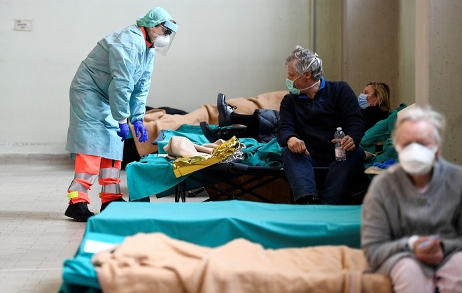Nhân viên y tế và bệnh nhân tại một bệnh viện ở Brescia, Italy, hôm 13/3. - Ảnh: Reuters.