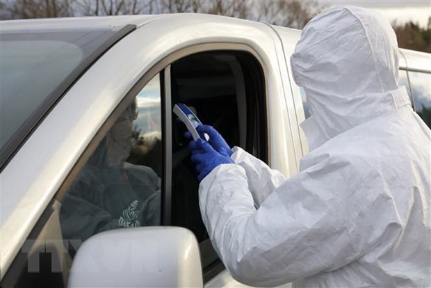 Nhân viên biên phòng Ba Lan kiểm tra thân nhiệt của một lái xe tại khu vực biên giới Ba Lan-Slovakia ngày 11/3. (Nguồn: PAP/TTXVN)