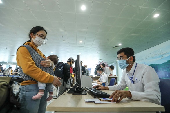 Hành khách làm thủ tục khai báo y tế tại sân bay Nội Bài - Ảnh: NGUYỄN KHÁNH