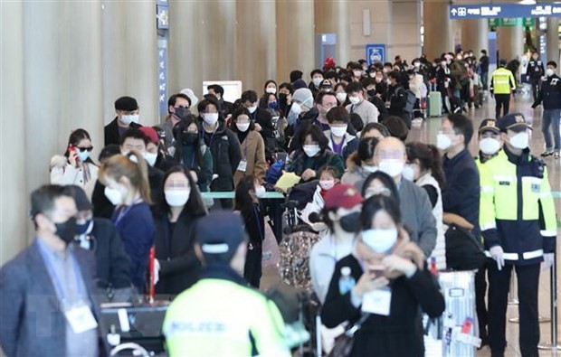 Hành khách đến từ Frankfurt, Đức, tại sân bay quốc tế Incheon, Hàn Quốc ngày 24/3/2020, chờ xe buýt để tới khu vực cách ly trong bối cảnh dịch COVID-19 lan rộng. (Nguồn: THX/ TTXVN)