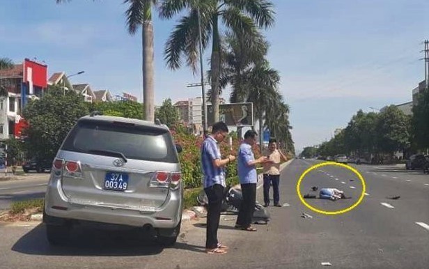 Hình ảnh 3 người đàn ông đứng bấm điện thoại còn nạn nhân nằm giữa đường sau tai nạn. - Ảnh: Zing.vn