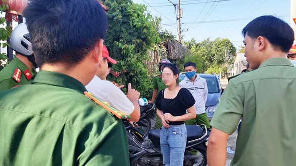Lực lượng chức năng làm việc với một phụ nữ trong nhóm người Trung Quốc bỏ chạy khỏi khu lưu trú tại tỉnh Quảng Nam chiều 18/7 - Ảnh: Tuổi Trẻ