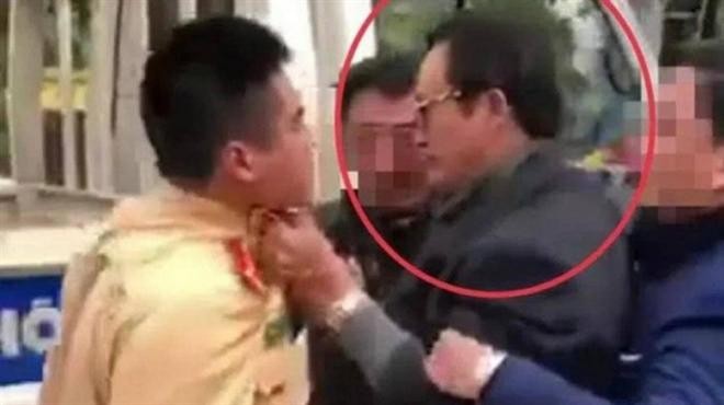 Ông Lê Quốc Đạt túm cổ áo chiến sĩ CSGT - Ảnh: Cắt từ clip