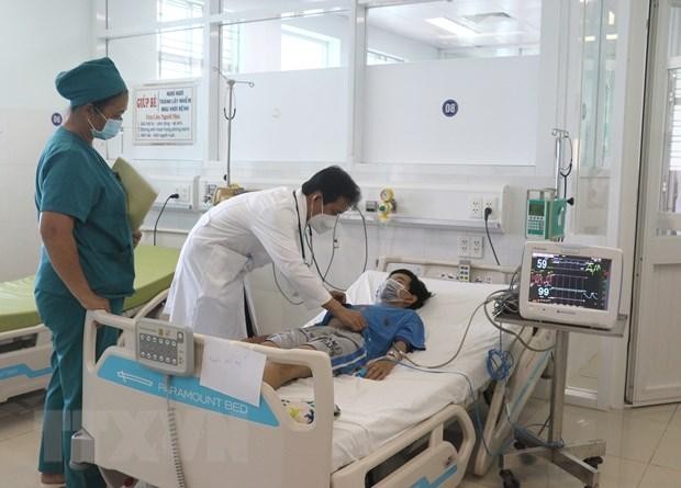 Bác sỹ Bệnh viện Đa khoa tỉnh Vĩnh Long thăm khám cho bệnh nhi bị sốc do sốt xuất huyết trong tình trạng nặng. (Ảnh: TTXVN)
