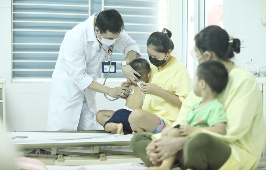 Bác sĩ thăm khám cho bệnh nhi đang điều trị cúm A tại Bệnh viện Bệnh nhiệt đới Trung ương. (Ảnh: TTXVN)