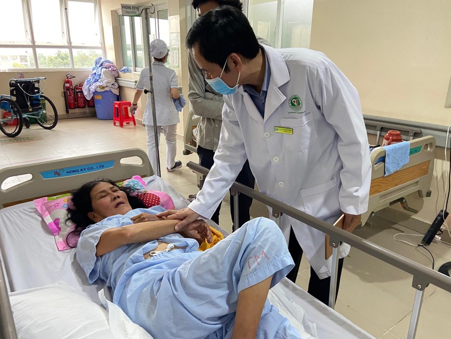 Bác sĩ Trần Văn Khanh - Giám đốc Bệnh viện Quận 2 đang thăm hỏi bệnh nhân vừa qua cơn nguy kịch do đột quỵ não. Ảnh: Ngọc Giàu 
