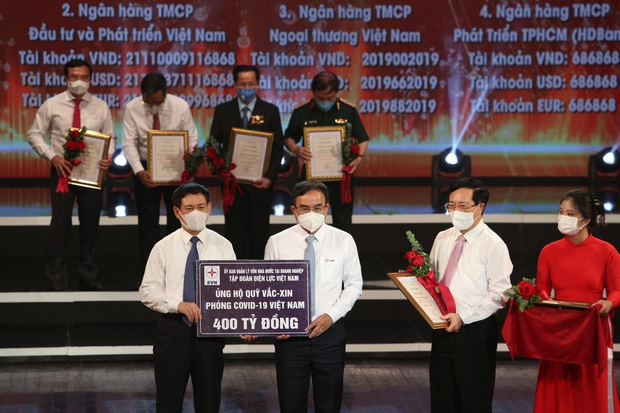 Chủ tịch HĐTV EVN Dương Quang Thành (giữa) trao biểu trưng số tiền 400 tỷ đồng ủng hộ Quỹ vắc-xin phòng chống COVID-19. Ảnh: EVN.