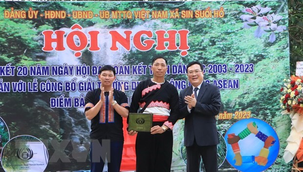 Giám đốc Sở Văn hóa Thể thao và Du lịch tỉnh Lai Châu Lương Chiến Công trao chứng nhận giải thưởng du lịch cộng đồng ASEAN cho điểm bản Sin Suối Hồ. Ảnh: TTXVN.