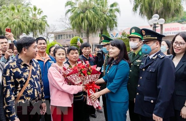 Lãnh đạo thành phố Móng Cái tặng hoa chúc mừng các đoàn khách quốc tế đầu tiên qua cửa khẩu quốc tế Móng Cái. Ảnh: TTXVN.