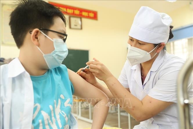 Nhân viên y tế quận Hà Đông tiêm vaccine phòng COVID-19 cho học sinh lớp 6 tại điểm tiêm chủng trường THCS Lê Quý Đôn. Ảnh: Minh Quyết/TTXVN.