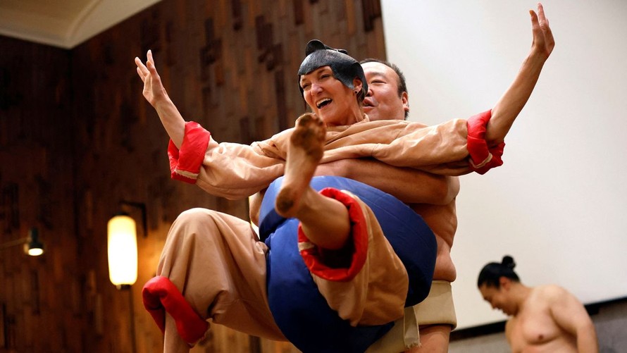 Một du khách người Mỹ mặc đồ đô vật sumo khi thi đấu trải nghiệm với một cựu đô vật tại Tokyo, Nhật Bản. Ảnh: Reuters.