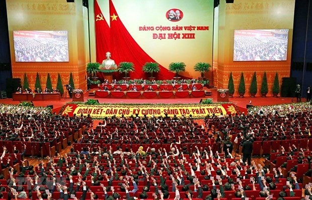 Các đại biểu biểu quyết, thông qua Nghị quyết Đại hội XIII của Đảng. Ảnh: TTXVN.