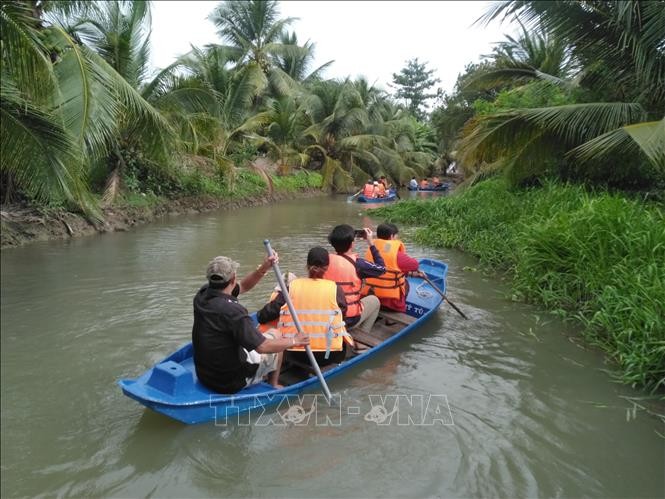 Du khách trải nghiệm hoạt động tự bơi xuồng trên sông trong Nông trại dê sữa du lịch Đông Nghi. Ảnh: Minh Hưng/TTXVN.
