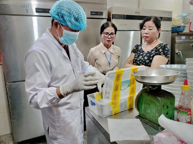 Chi cục An toàn vệ sinh thực phẩm TP. Hội An lấy mẫu thực phẩm tại cơ sở Bánh mì Phượng để gửi đi xét nghiệm. Ảnh: VGP.