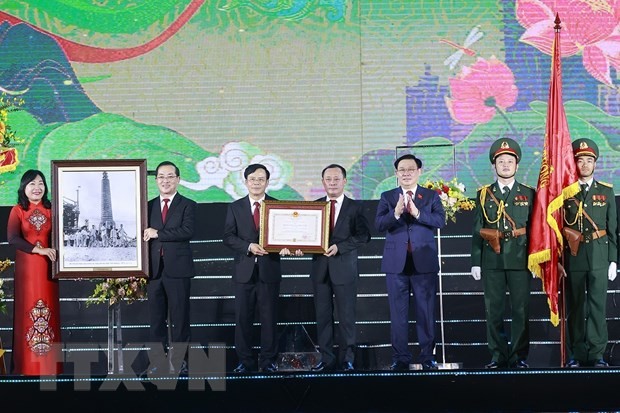 Chủ tịch Quốc hội Vương Đình Huệ trao Huân chương Độc lập hạng Nhì và tặng ảnh Bác Hồ, chúc mừng Đảng bộ, chính quyền và nhân dân thành phố Vinh. Ảnh: Doãn Tấn/TTXVN.