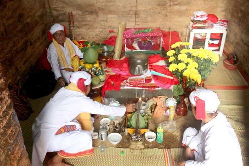 Chức sắc tôn giáo người Chăm thực hiện các nghi lễ chính của lễ hội Katê mở cửa tháp, tắm bệ thờ Linga-Yoni. Ảnh: Nguyễn Thanh/TTXVN.